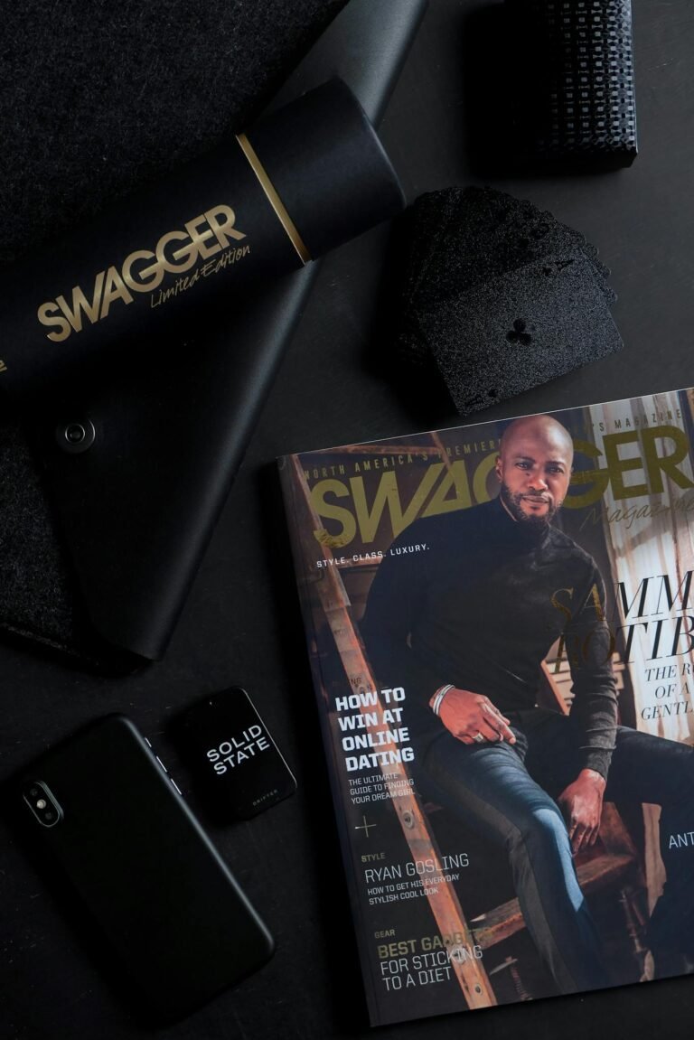 A dark and stylish flat lay featuring a magazine and tech items for a sleek look.